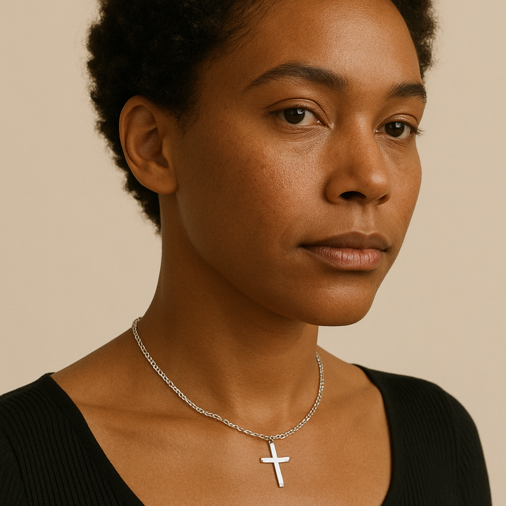 black woman wearing small silver cross necklace – fashion-forward stainless steel jewelry
