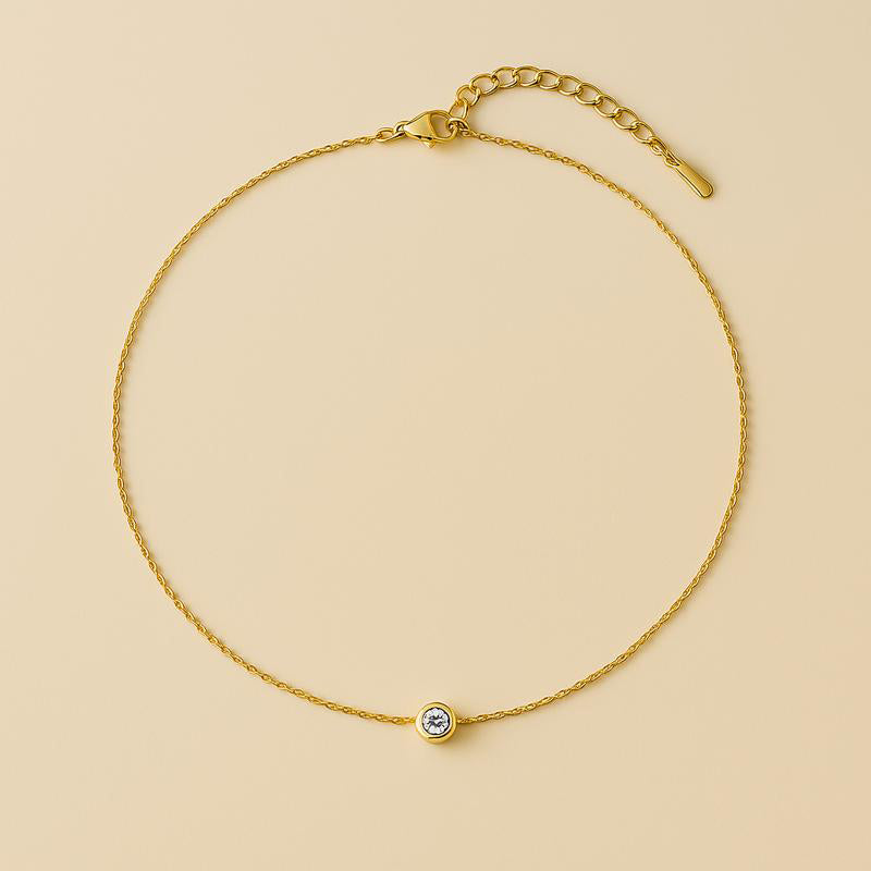 close-up of single diamond necklace with 14k gold chain – floating pendant on soft oat background
